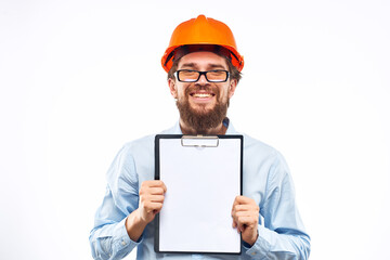 A man in an orange hard hat with documents Industrial activity work