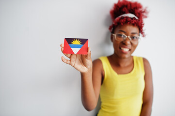 African american woman with afro hair, wear yellow singlet and eyeglasses, hold Antigua and Barbuda flag isolated on white background.