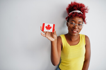 African american woman with afro hair, wear yellow singlet and eyeglasses, hold Canada flag...