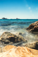 Sea wave crashes against rocks - long exposure and blur - power of water