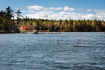 Fox Pond in Hancock County Maine on a sunny day with fall foliage.