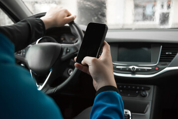Naklejka premium Man using mobile phone in the car. Driving car. Danger. 