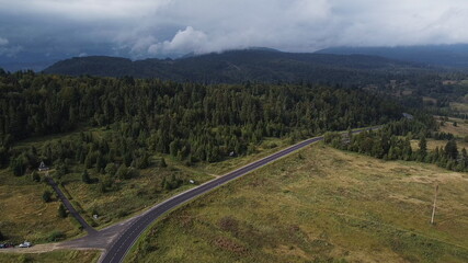 Aerial view descending over a mountain road covered by fog at sunrise