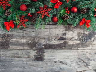 Red Christmas ornament, fir tree and pine cone on wooden background