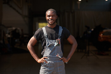 portrait of confident successful auto mechanic man of african appearance, young male likes working...