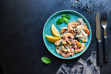seafood salad or appetizer shrimp, mussels, squid and other ingredients top view copy space for text food background rustic pescetarian diet