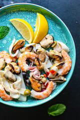seafood salad or appetizer shrimp, mussels, squid and other ingredients top view copy space for text food background rustic pescetarian diet