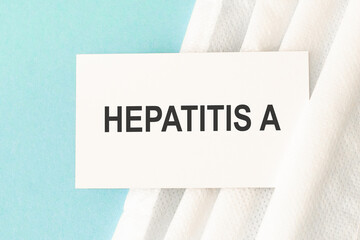 Word hepatitis a with medical mask on a blue background.