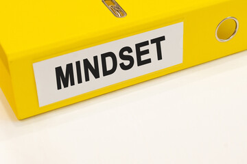 The word mindset on a white background with a yellow folder. Business concept