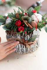 Creating Christmas floral arrangement with carnations, chrysanthemum santini flowers and fir.