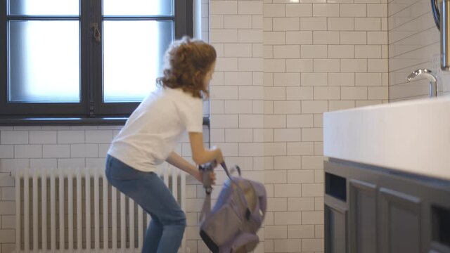 Upset and bullied schoolgirl sitting on floor in restroom and crying