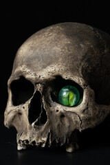 Human skull isolated on black background with glass eye