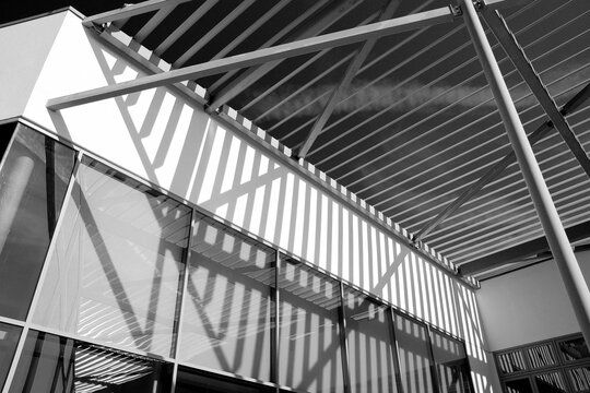 Grayscale photo of glazed canopy roof and school building