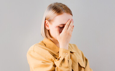 Embarrassed annoyed adult woman hiding face bend head down, facepalm, smirk irritated, not looking...