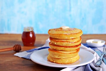 Cornmeal pancakes on a white plate.