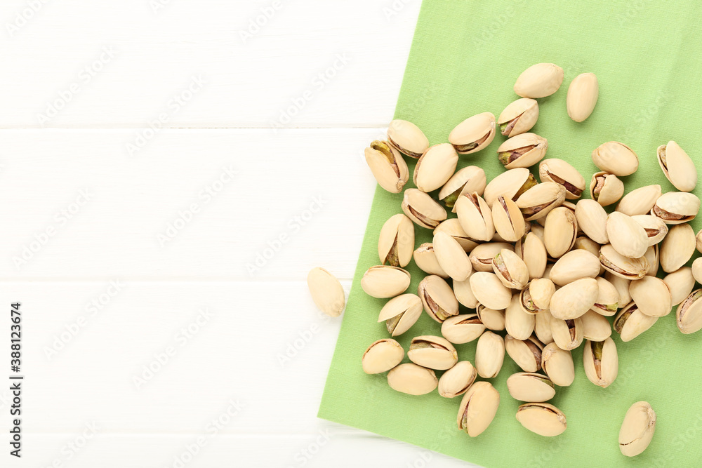 Poster pistachios with green napkin on white wooden table