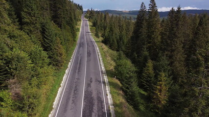 Aerial shot serbia. Drone flight over the mountains over the road that winds between the mountains with a beautiful view of green trees and cliffs.