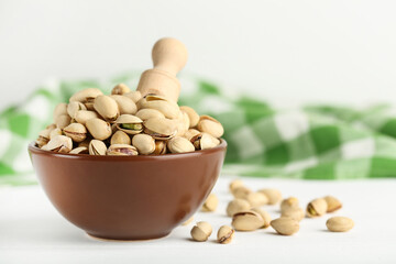 Pistachios in bowl on white wooden table