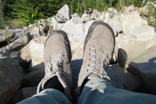 Neutrale graue Barfu&szlig;schuhe in der Sonne vor sandigem grauen Steinen . Outdooraktivit&auml;ten f&uuml;r die F&uuml;&szlig;e . Fu&szlig;ansicht . Bird Perspective on Foot perspective . bare foot shoes in matching environment .