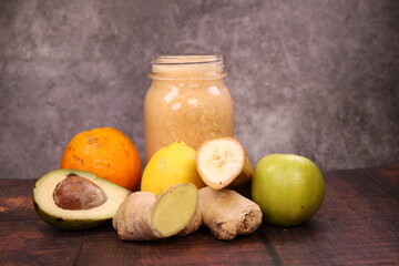 Delicious tropical Smoothie with orange, banana, apple, lemon, avocado, and ginger