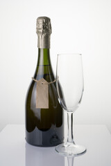 Elegant champagne bottle and wine glass on a light background. The concept of festive drinks.