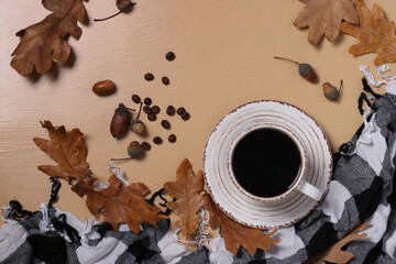 Acorn coffee with fall oak leaves and checkered scarf on beige background. Coffee substitute...