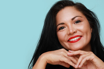 Close-up of beautiful mature woman with beautiful smile. Isolated on blue background wall.