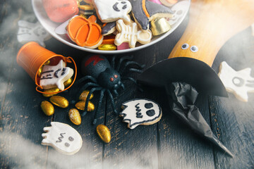 pumpkin in a black witch hat, a bowl of chocolates and sweets, Halloween Jack o Lantern cookies - Trick or Treat Halloween card background