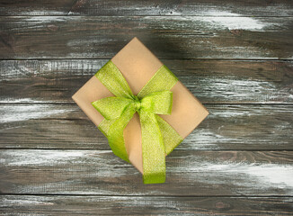 Gift box with a bow on a wooden background.