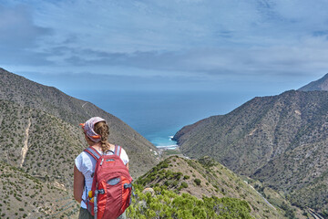 Fototapeta premium Hiking through the panoramic mountain landscape in La Gomera, Spain. Hiker in the mountains in La Gomera, Spain. View from the mountains in La Gomera on the ocean.