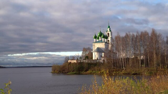 The sunlit Church of the Holy Trinity in the village of Dievo Gorodishche in the Yaroslavl region, Russia. Dawn on the Bank of the Volga river.