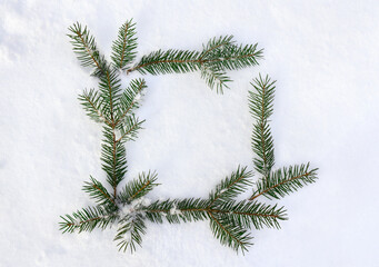 Christmas decoration. Frame of twigs christmas tree on snow with space for text. Top view, flat lay