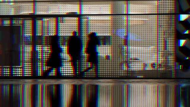 People walking in front of a shop window at night. Video with prismatic effect.
