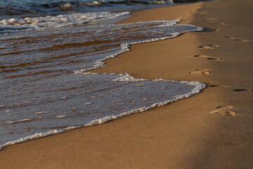 Small sea waves crossing beach sand