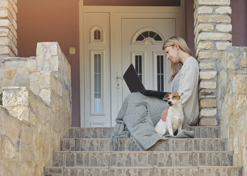 Cozy Home, Dog Sitting Next To Woman Using Laptop , Sitting On Steps On A Front Porch. Relax, Carefree, Comfort Lifestyle.