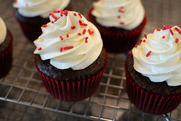 chocolate cupcake with whipped cream frosting and red sprinkles