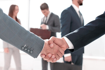 close up.handshake business partners in the background of the office