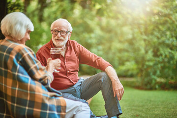 Smiling elderly spouses on a date in the garden