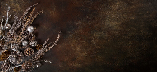 Naklejka premium Christmas background, the composition of their cones and dried flowers on a dark brown background. Abstract composition, idea, decor.