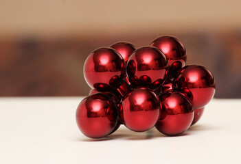 A bunch of red ornaments on a white surface with a brown color blurry background