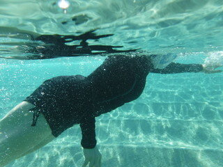 Chica esnorqueleando en mar de aguas cristalinas