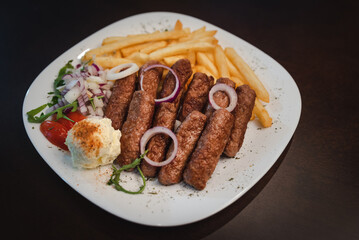 peceni rostilj sa pomfitom i salatom na tanjiru, srpsko jelo 