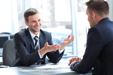 business partners talking while sitting at your Desk