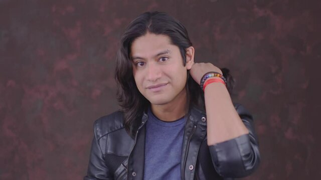 chico hispano bien parecido pein&aacute;ndose se siente feliz y satisfecho