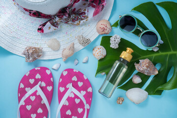 beautiful beach background with sandals hat sunglasses body oil and monstera, summer accesories