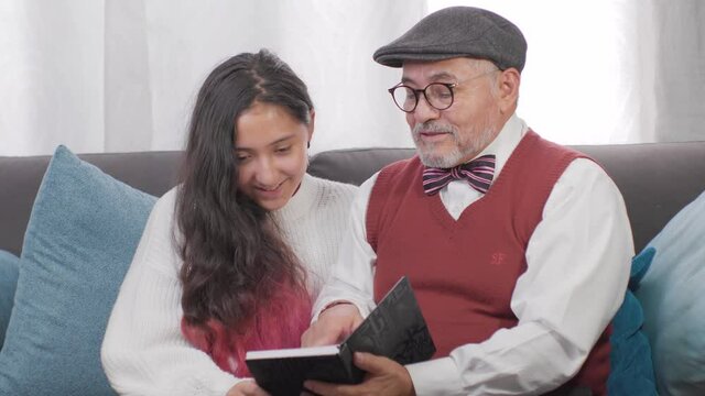 abuelo con su bella nieta en casa leyendo una historia felices y tranquilos 