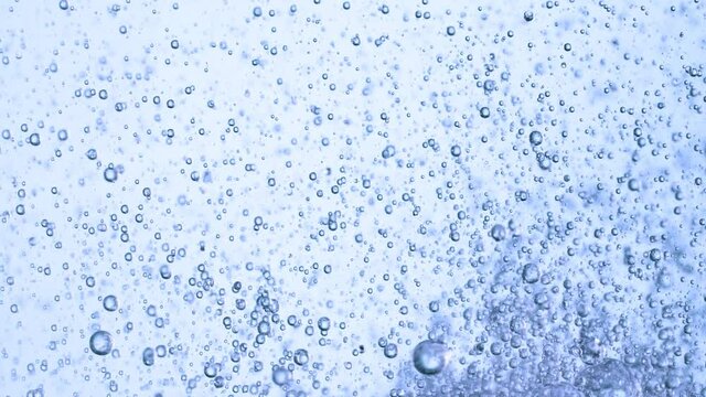 Super Slow Motion Shot of Moving Gel Bubbles in Water on Light Blue Background at 1000fps.