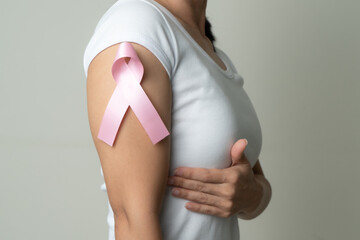 pink badge ribbon on woman arm to support breast cancer cause. b