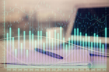 Double exposure of financial graph drawings and desk with open notebook background. Concept of forex market