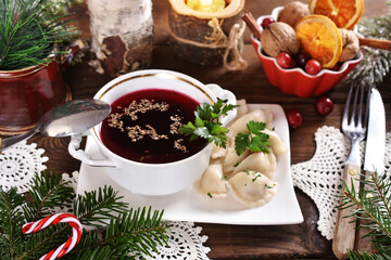 Obraz na płótnie Canvas traditional in Poland Christmas Eve red borscht and dumplings with sauerkraut and mushroom filling